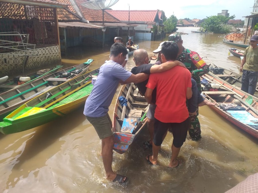 Babinsa Koramil 406-02/Rawas ilir serma endang membantu warga menyebrangi sungai didesa binaan.