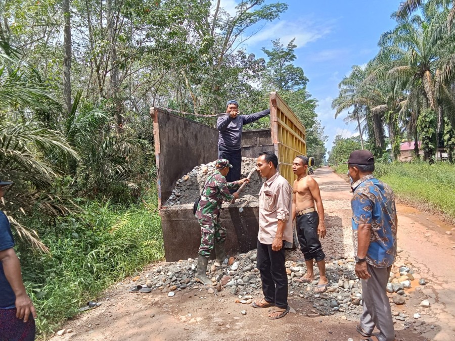 Babinsa Bersama Warga Gotong-royong Timbun Jalan Berlubang di wilayah binaan