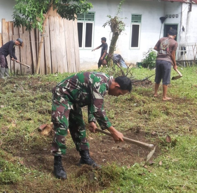 Peduli Lingkungan, Babinsa Bersama Warga Gotong Royong Bersihkan Rumput di sekitar kantor desa di wilayah binaan