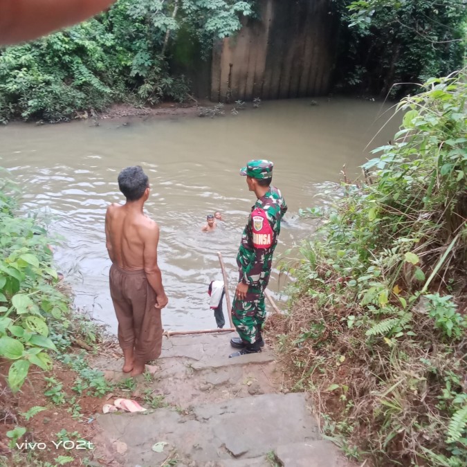 Babinsa Koramil 406-07/Jayaloka Himbau Warga Waspada Banjir Saat Mandi di Sungai