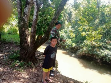 Babinsa Koramil 406-07/Jayaloka Himbau Anak-Anak di Desa Temelat Agar Tidak Bermain di Sungai Saat Musim Penghujan