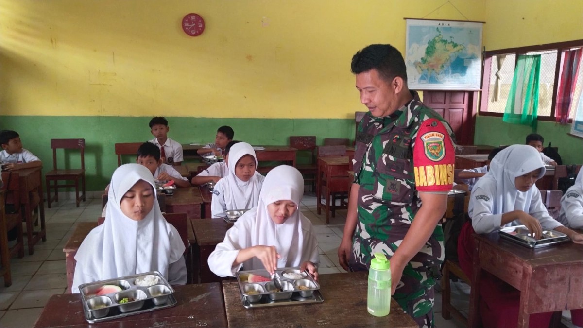 Sukseskan Program Makanan Bergizi Gratis (MBG) Babinsa Dampingi Proses Pendistribusian Ke Sekolah